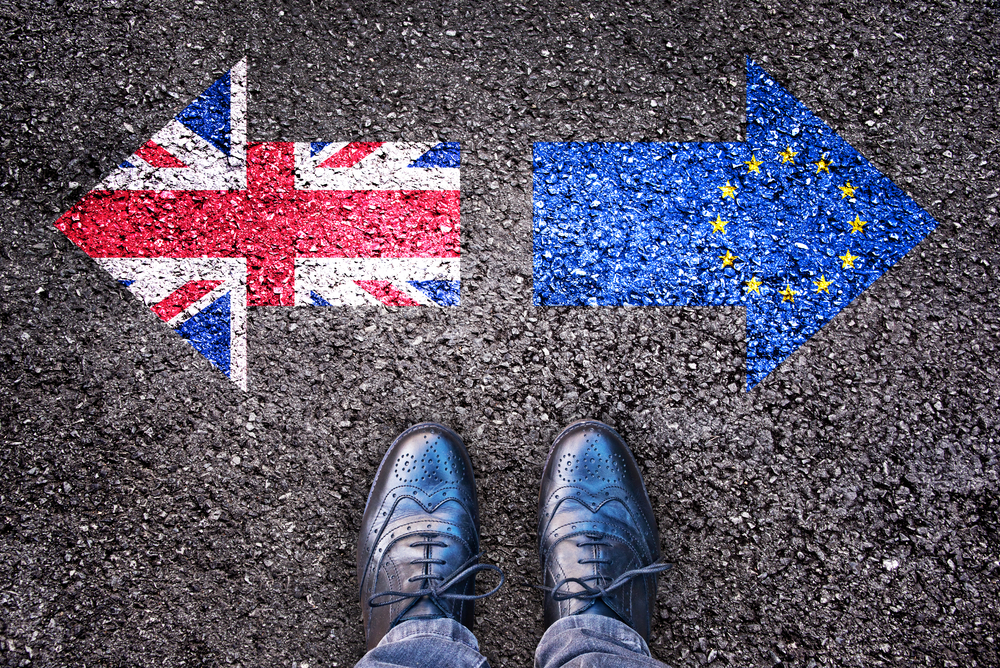 Füße auf der Straße mit Pfeil nach links für Brexit und Pfeil nach rechts für Europa